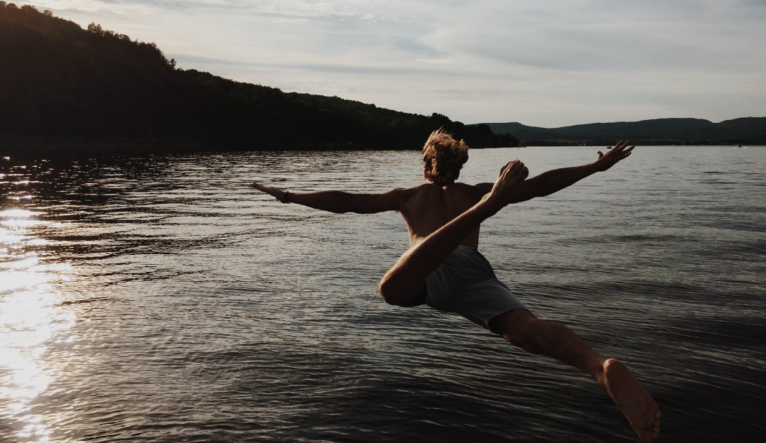 An image of a man diving into a lake represents a software developer jumping into serverless development