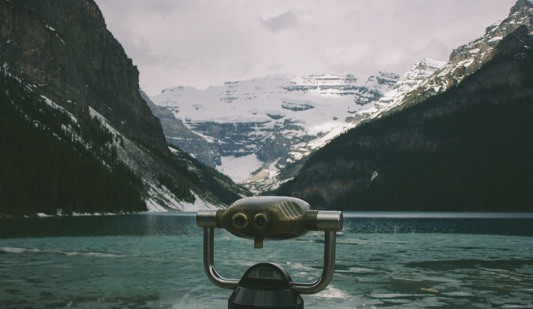 An image of binoculars and a winter landscape.